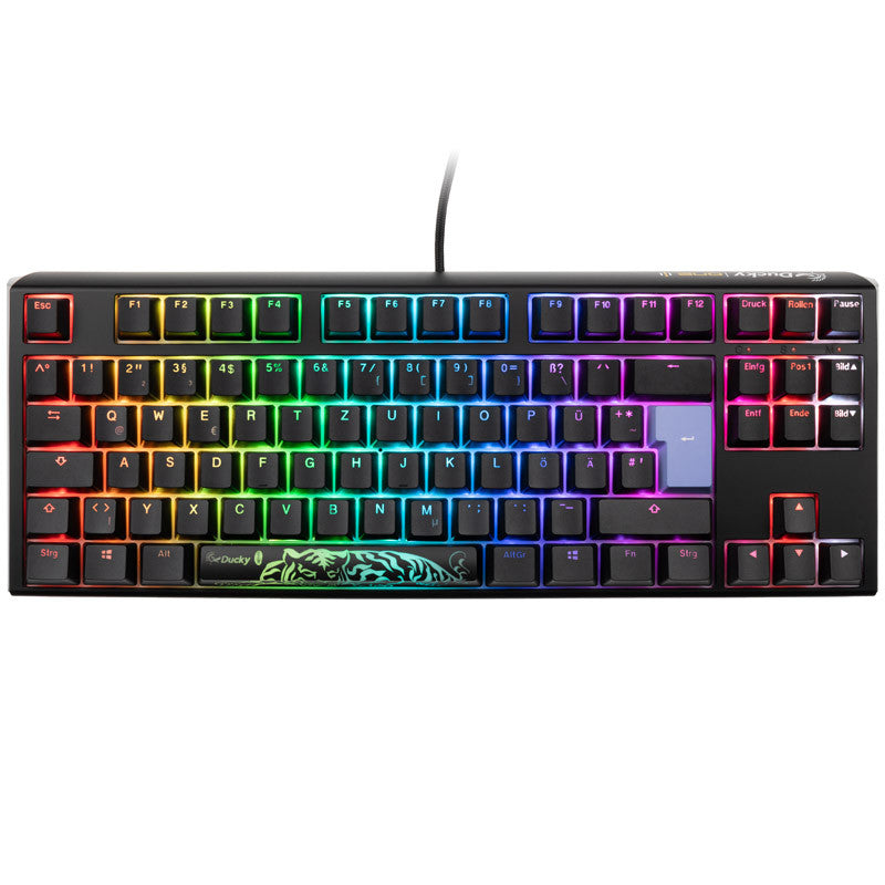 A colorful backlit mechanical gaming keyboard with vivid rainbow lighting across keys, featuring a distinct green tiger decal on the spacebar and equipped with Ducky One 3 - Classic Black / White Nordic - TKL - Cherry Blue switches.